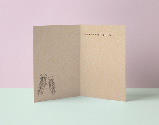 Folded kraft recycled card with jellyfish illustration and text saying to my once in a lifetime poetry.