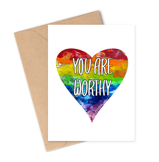 Greeting card with rainbow heart and 'You are Worthy' text on a white background with brown envelope.