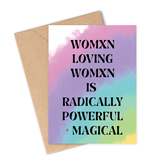 Greeting card with rainbow watercolor design and text 'WOMXN LOVING WOMXN IS RADICALLY POWERFUL + MAGICAL' on a white background.