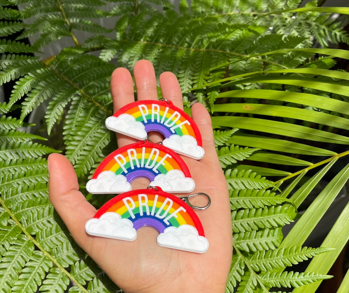 Three handmade 3D printed Rainbow Pride Arcs with clouds Keychains